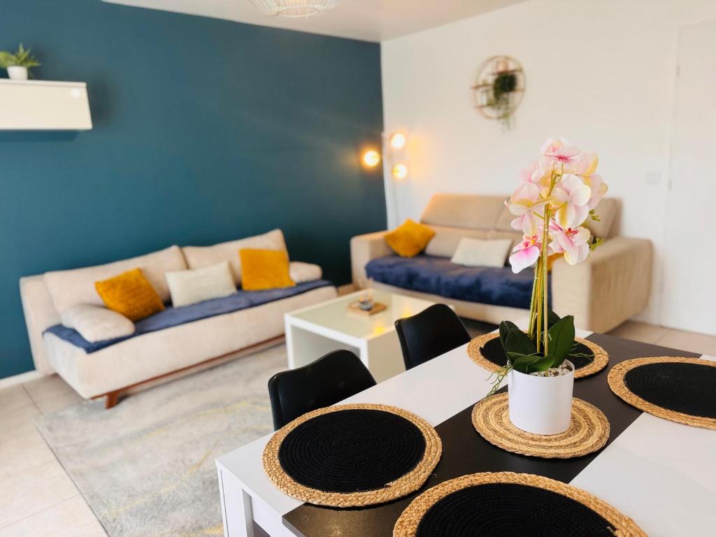un salon avec une table et un canapé dans l'établissement Appartement lumineux Parking proche transport, au Bourget