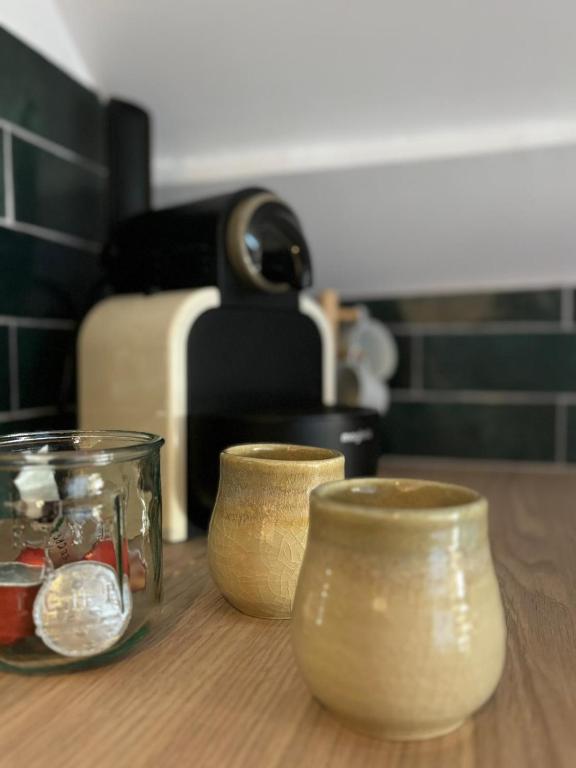 trois bocaux en verre assis sur une table en bois dans l'établissement Hyper centre Sous les toits Auxerre, à Auxerre