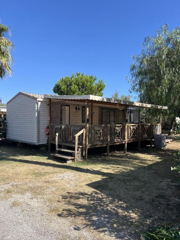 une petite maison avec une clôture devant dans l'établissement Camping Del Mar B10, Mobile Home Excellence, 3 chambres, 6 personnes, bord de mer, à Argelès-sur-Mer