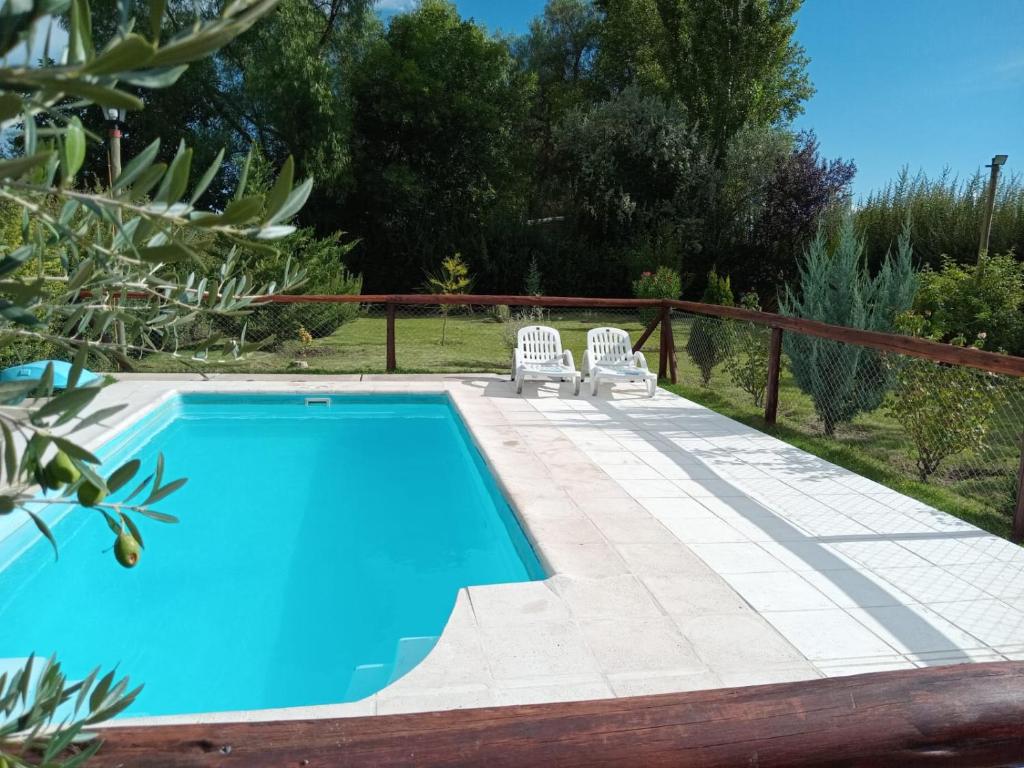 a swimming pool with two lawn chairs next to it at Complejo BenjaLuna in San Rafael
