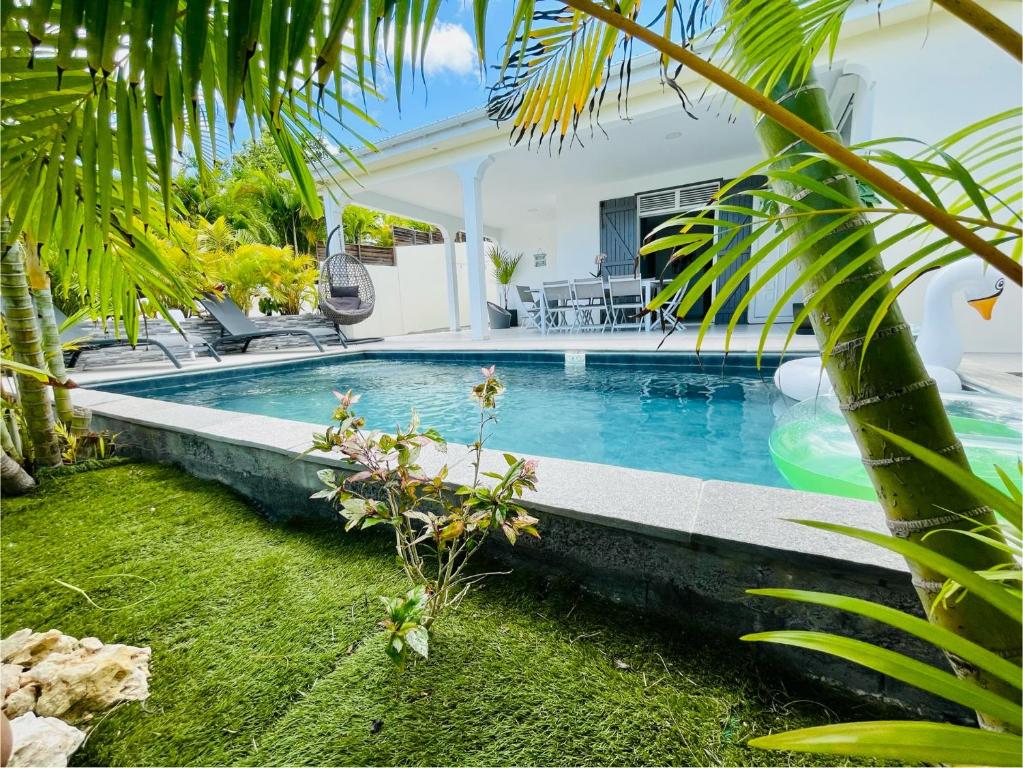 a swimming pool in a villa with palm trees at Villas TROPICAL & EXOTIC, 6 chambres avec 2 piscines in Le Moule