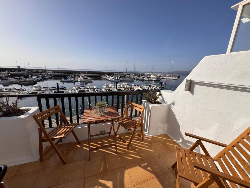 a balcony with a table and chairs and a marina at Eslanzarote Casa Eneida sea views, super wifi in Tías