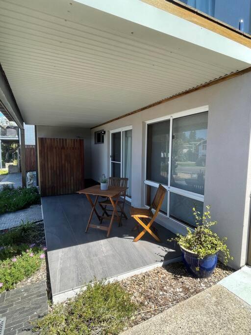 a patio with a table and a chair on a porch at Waterfront and direct beach access with views in Ulladulla