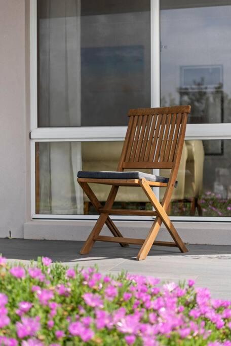 a wooden chair sitting in front of a window at Waterfront and direct beach access with views in Ulladulla