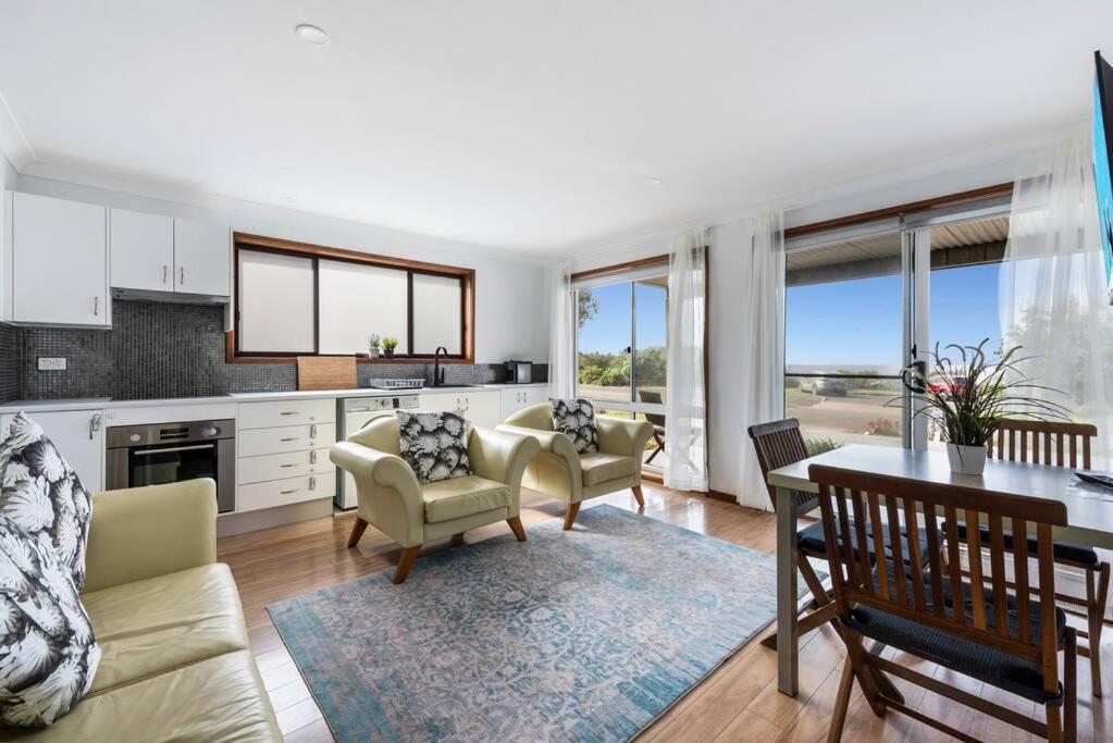 a kitchen and living room with a table and chairs at Waterfront and direct beach access with views in Ulladulla