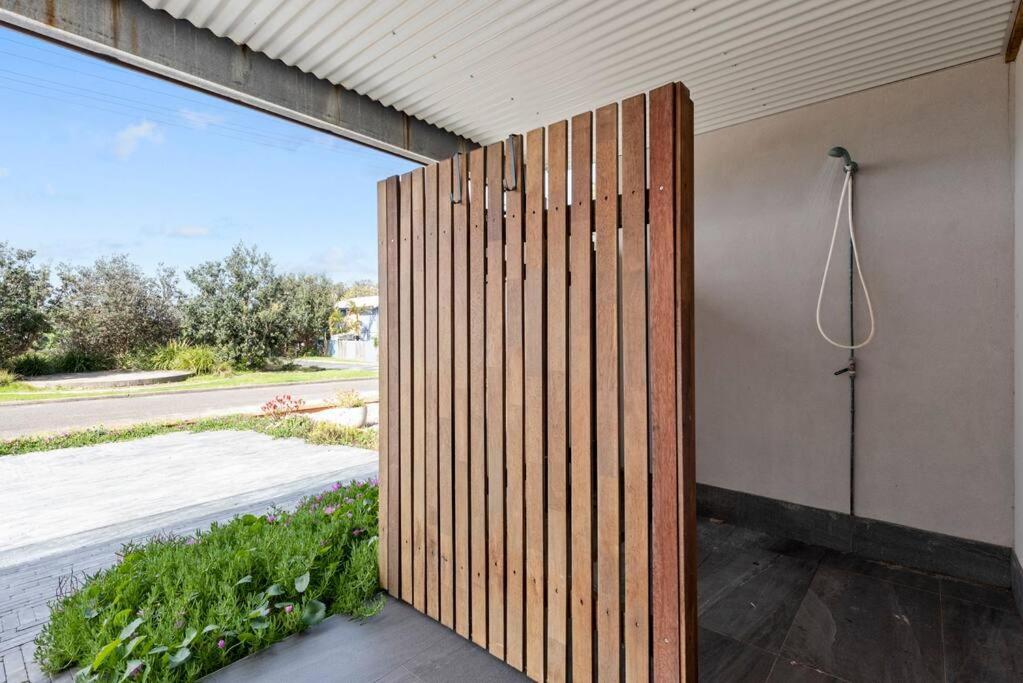 a wooden wall with a shower on the side of a house at Waterfront and direct beach access with views in Ulladulla