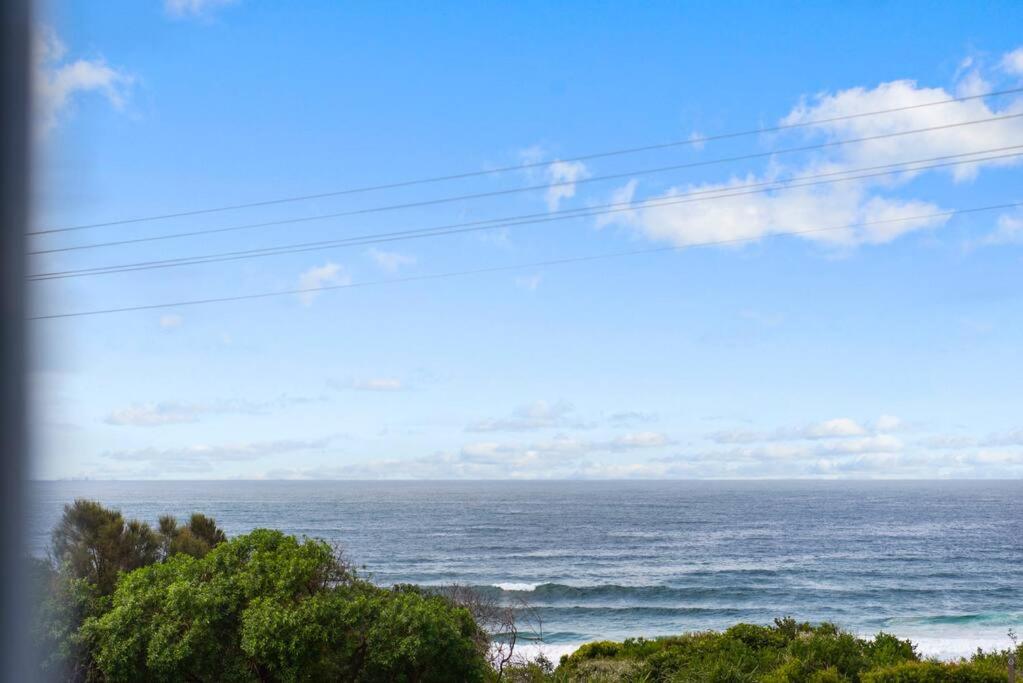 a view of the ocean from a window at Waterfront and direct beach access with views in Ulladulla