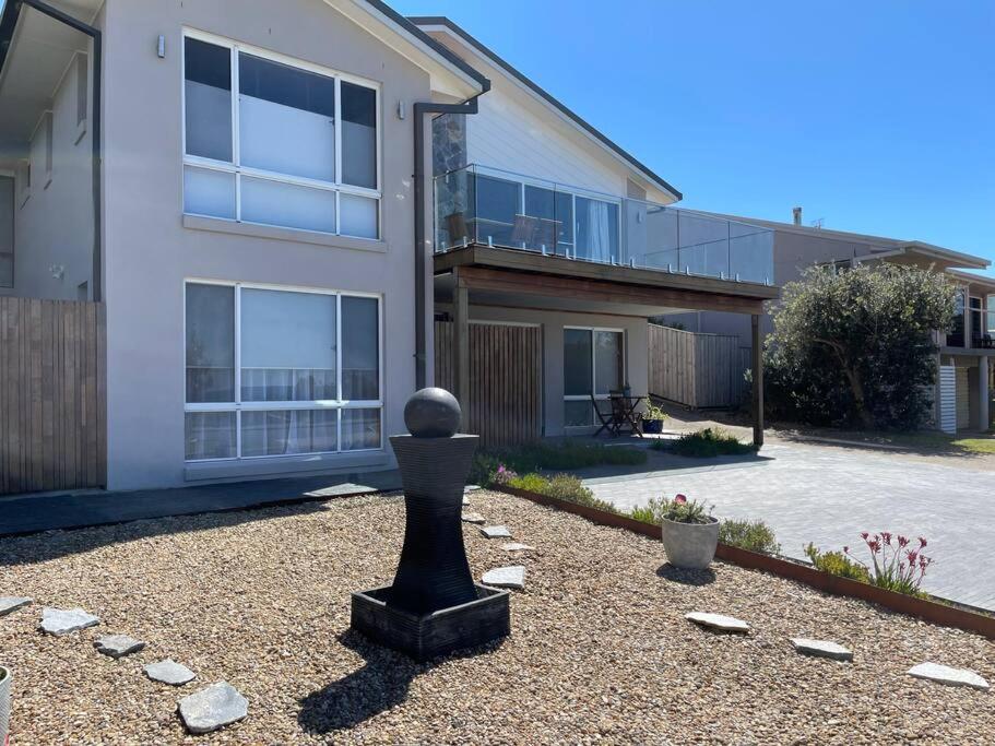 a house with a statue in the front yard at Waterfront and direct beach access with views in Ulladulla