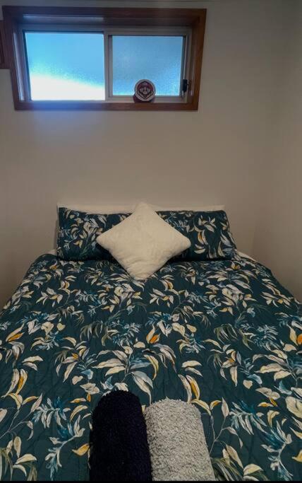 a bedroom with a bed with a pillow and a window at Waterfront and direct beach access with views in Ulladulla