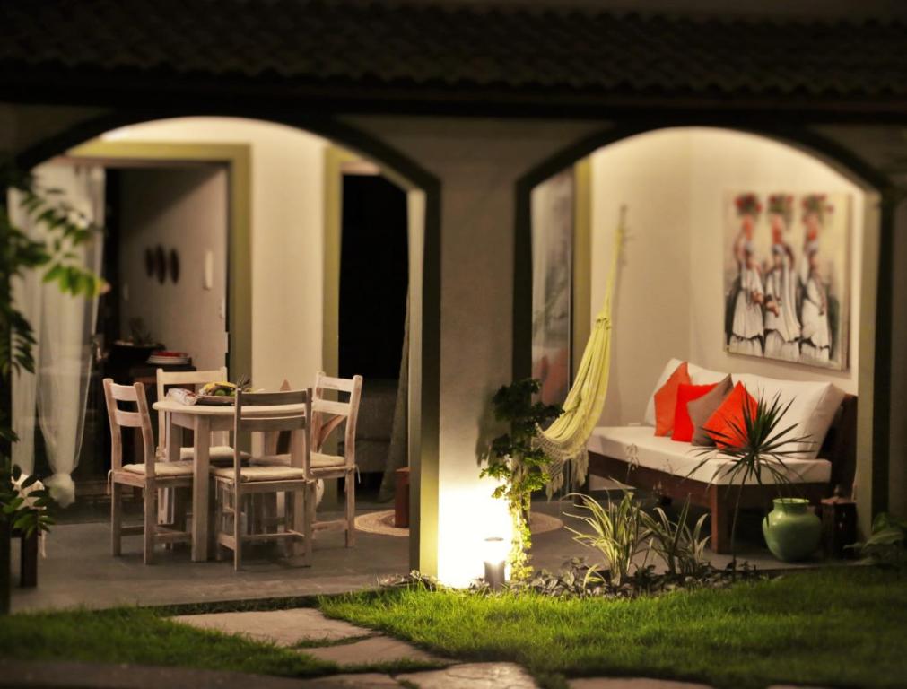 a patio with a table and chairs and a couch at Flor da Mata in Pipa