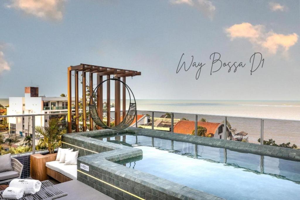 a view of the ocean from a balcony with a swimming pool at Way Bossa Praia do Bessa in João Pessoa
