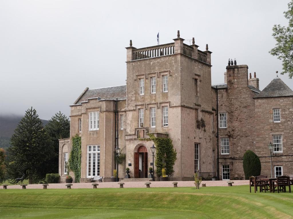 a large building with a clock on the front of it at Macdonald Pittodrie House in Chapel of Garioch