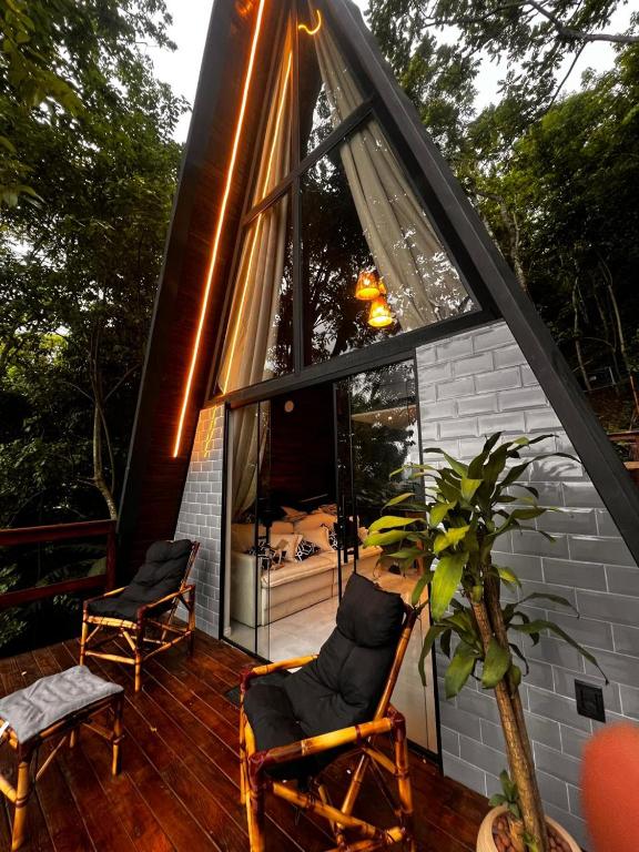 a house with a large window and two chairs on a deck at Lumiar Cabanas in Rio de Janeiro