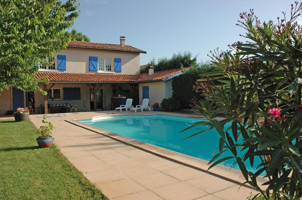 una casa con piscina en un patio en Le Relais Du Grand Logis en Civrieux