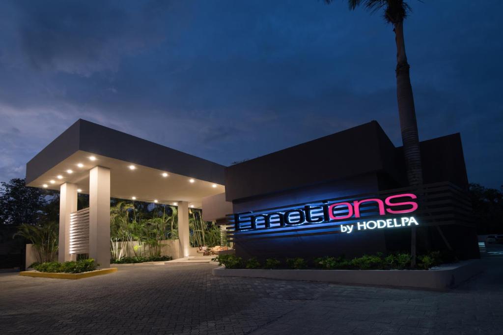 a building with a lit up sign at night at Emotions by Hodelpa - Juan Dolio in Juan Dolio