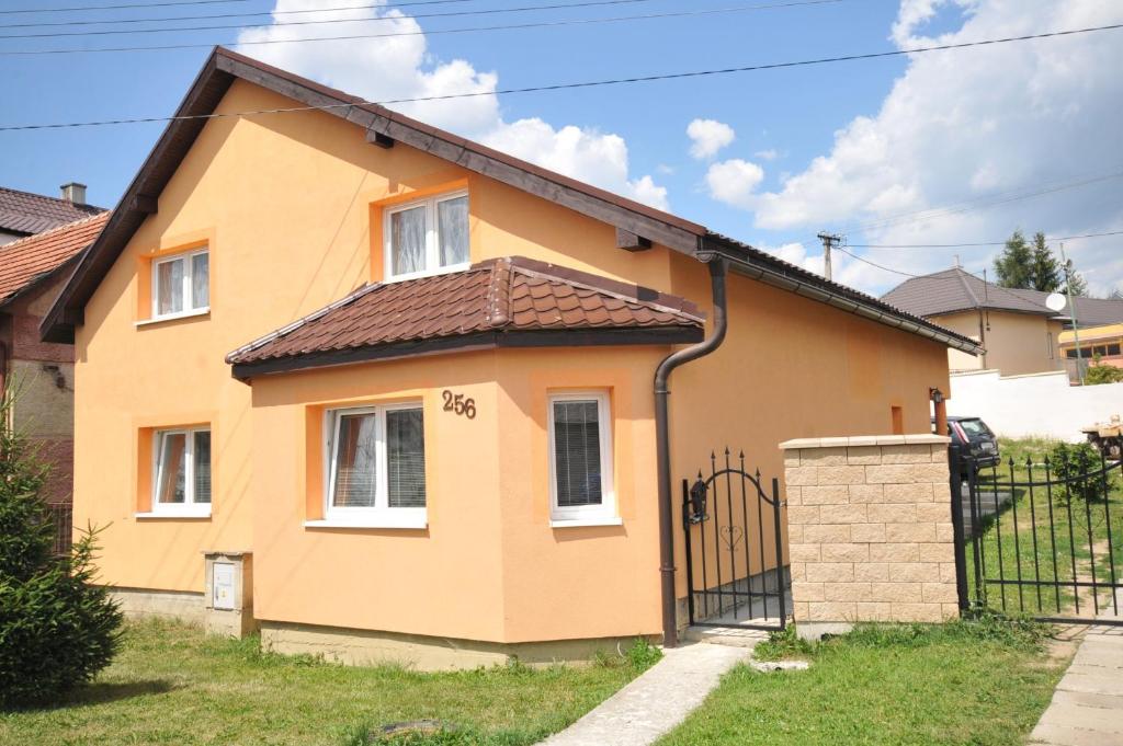 una casa amarilla con una puerta negra en Superubytovanie Olga, en Štrba