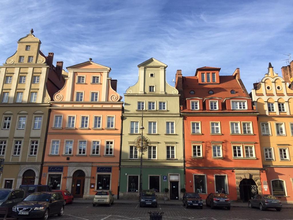 a group of buildings with cars parked in a parking lot at Mieszkanie Na Placu Solnym in Wrocław