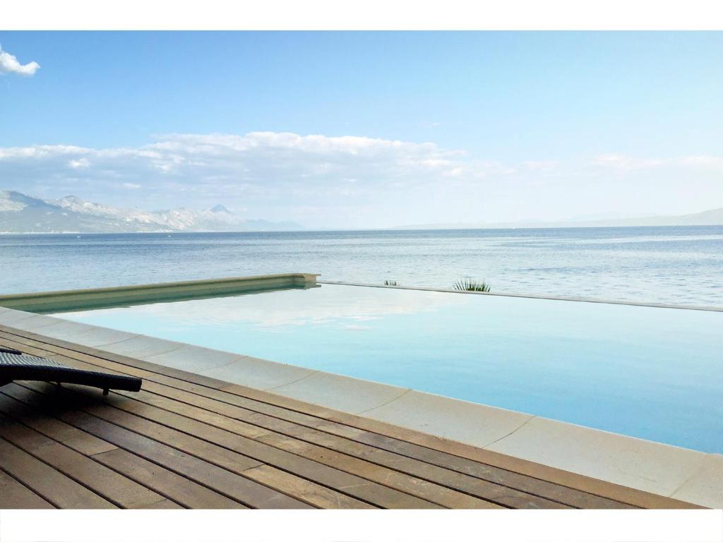 a swimming pool on a deck next to the water at Villa Luna in Sumartin