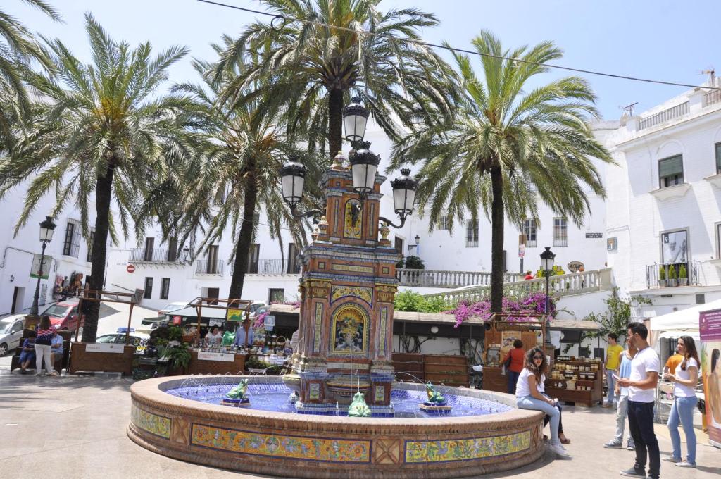 fontanna na środku ulicy z palmami w obiekcie Casa Andrea w mieście Vejer de la Frontera