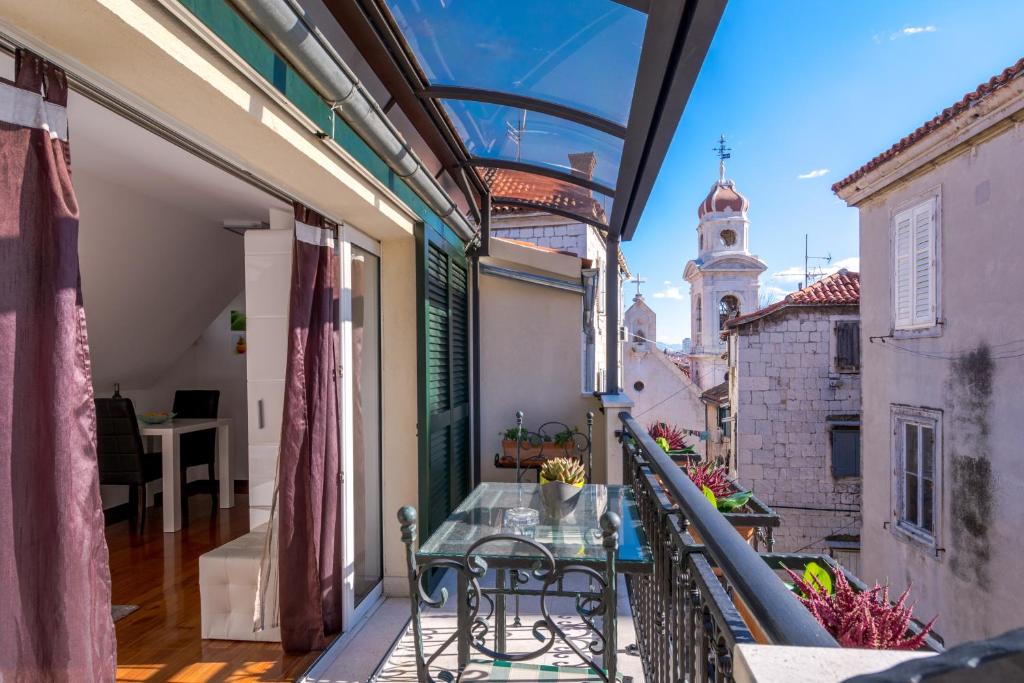 balcón con mesa y vistas a un edificio en Apartments and Rooms Villa Erede, en Split