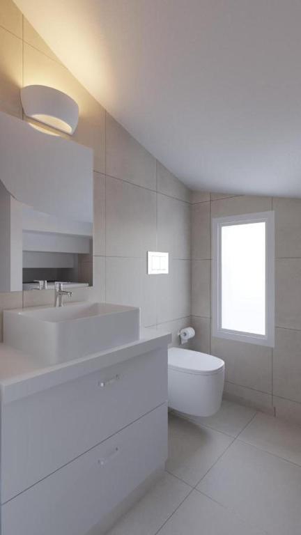 biała łazienka z umywalką i toaletą w obiekcie New Loft by Ossiano Pool Villas, Heating Pool,2 min drive to Haraki Beach & 10 to Lindos w mieście Charaki