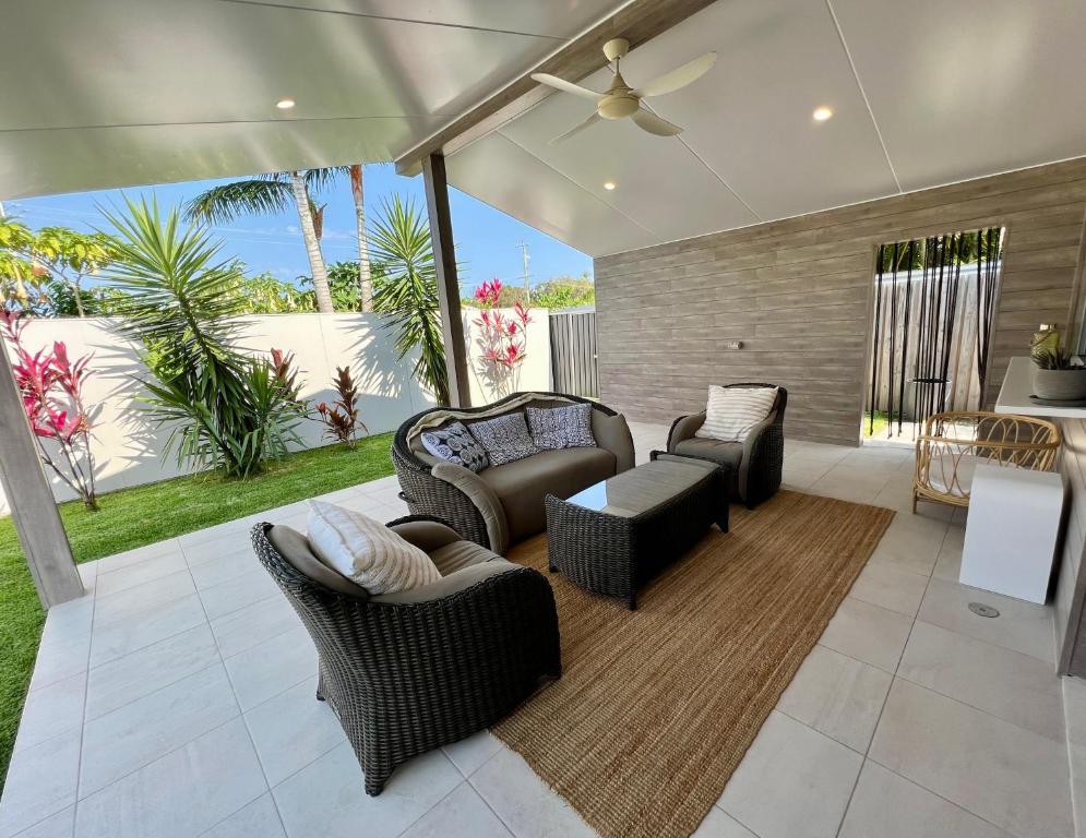 a living room with a couch and chairs and a table at Beachside retreat in Caloundra