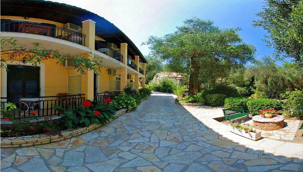 里亞帕德斯的住宿－Villa Katerina Apartments，花卉和植物的建筑旁的走道
