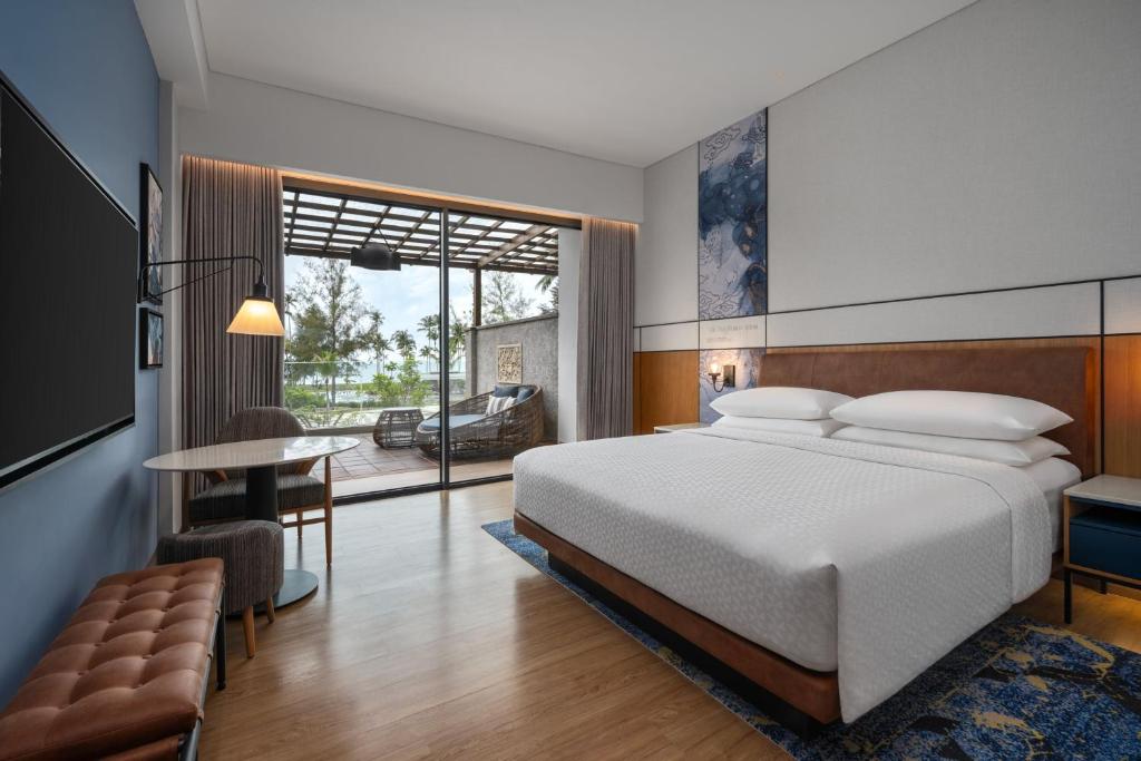 ラゴイにあるFour Points by Sheraton Bintan, Lagoi Bayのベッドと机とテーブルのある寝室