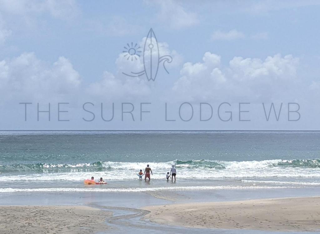 a group of people playing in the water at the beach at The Surf Lodge White Beach in Shimoda