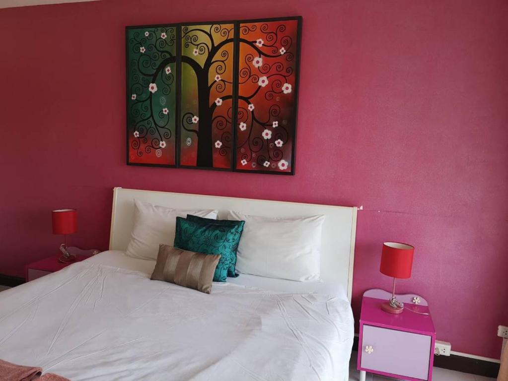 a bedroom with a white bed with a red wall at Standard Room in Kata Beach