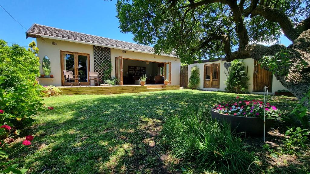 a house with a yard with flowers in the yard at Bird Song in Cape Town