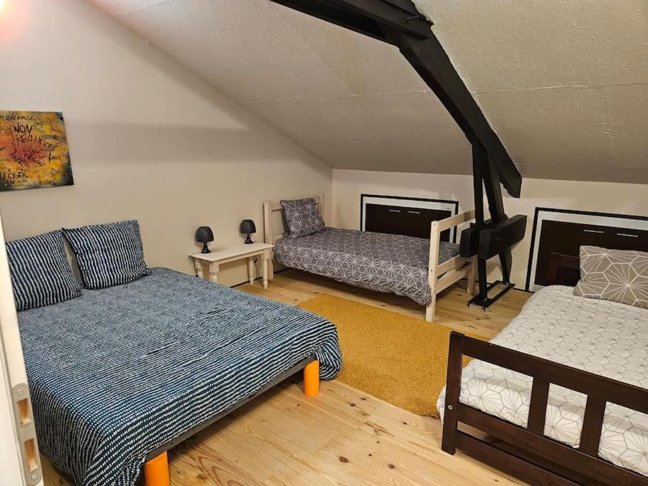 a living room with two beds and a couch at La salle de jeux in Saint-Lubin-en-Vergonnois