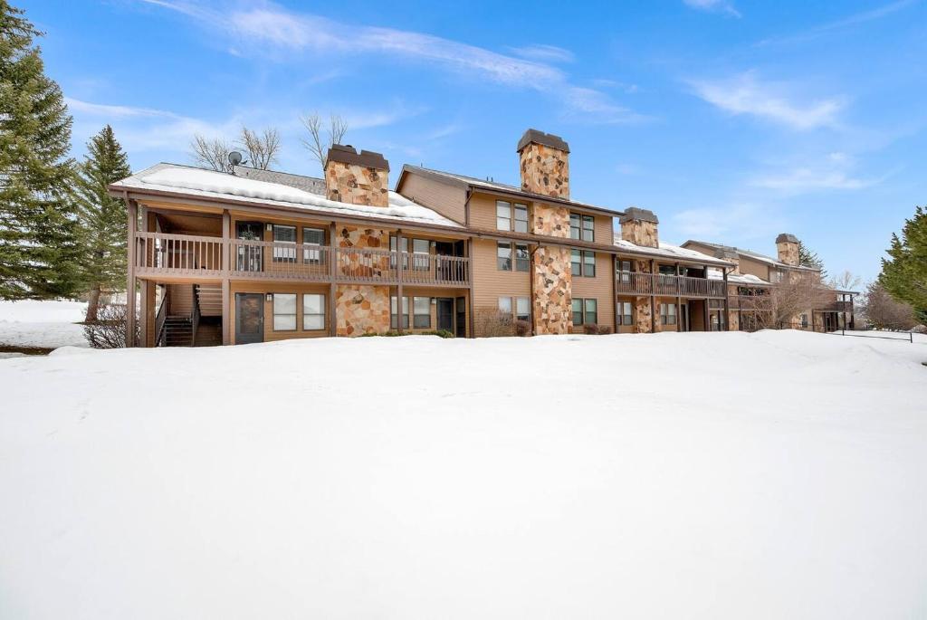 une grande maison dans la neige avec des terrains enneigés dans l'établissement Wolf Creek Lodge Condo in Eden, UT - Relaxing Mountain Retreat, à Eden