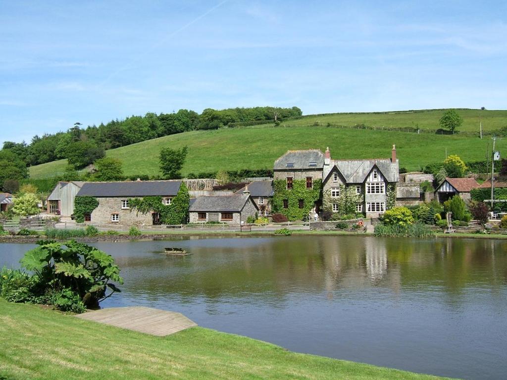 una casa grande junto a un lago grande en Malston Mill Farm, en Kingsbridge
