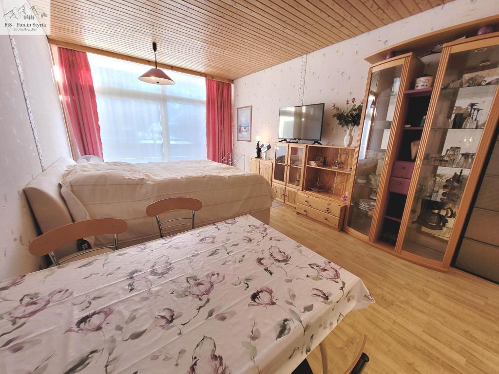 a bedroom with a bed and a table and a tv at Apartment Theresia by FiS - Fun in Styria in Bad Mitterndorf