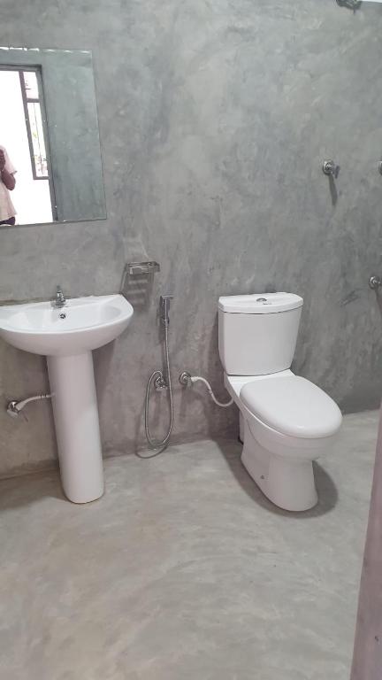 a bathroom with a toilet and a sink at Madiha Sampath Surf Villa in Matara