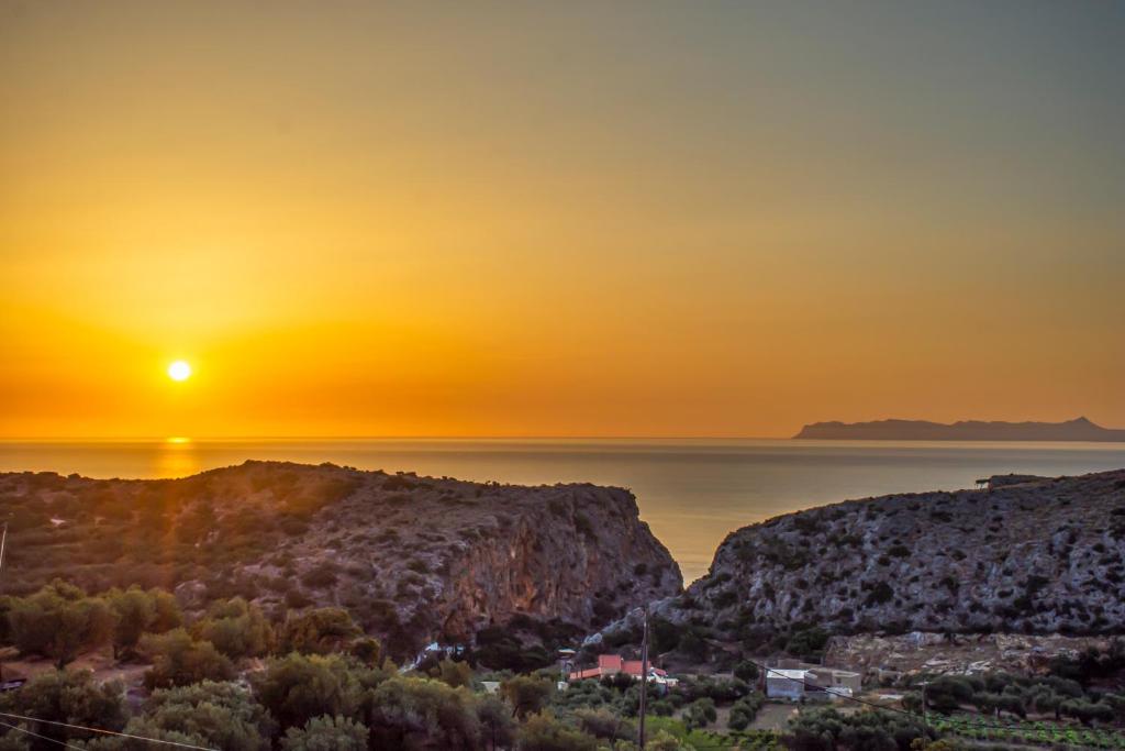a view of the sun setting over the ocean at Infinity Wellness Sea View Suites in Afráta