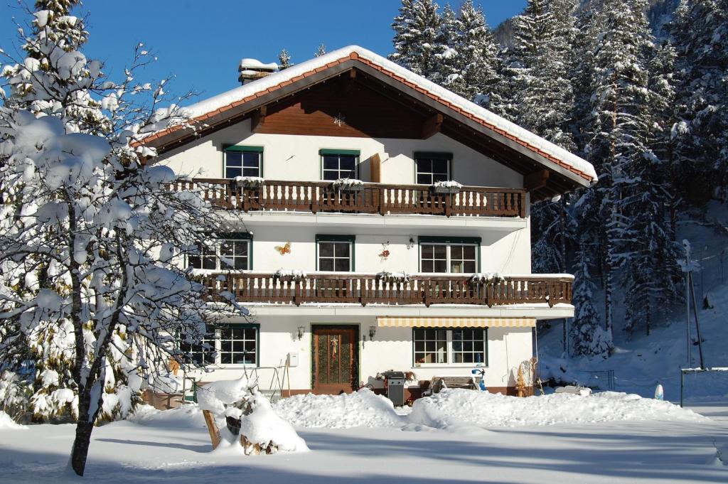 ein schneebedecktes Haus mit Balkon darüber in der Unterkunft Haus Waldrast in Elbigenalp