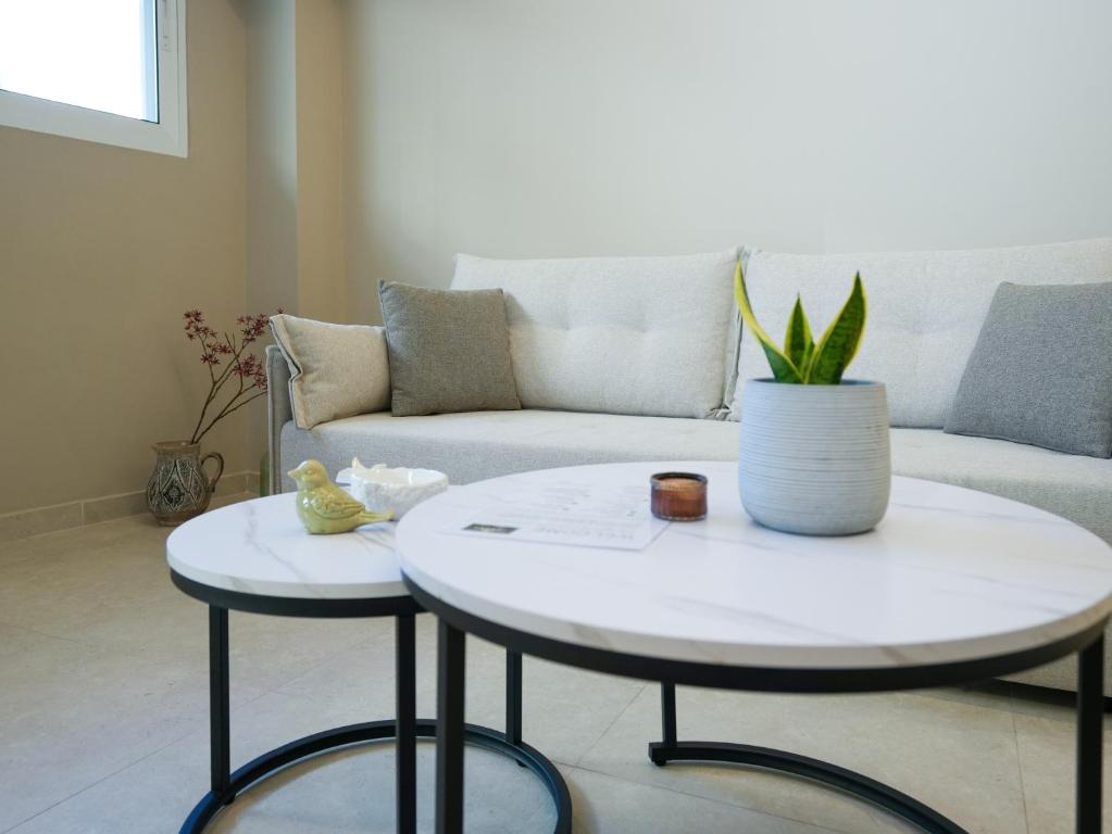 a living room with two tables and a couch at Azilo Urban Suites in Kos Town