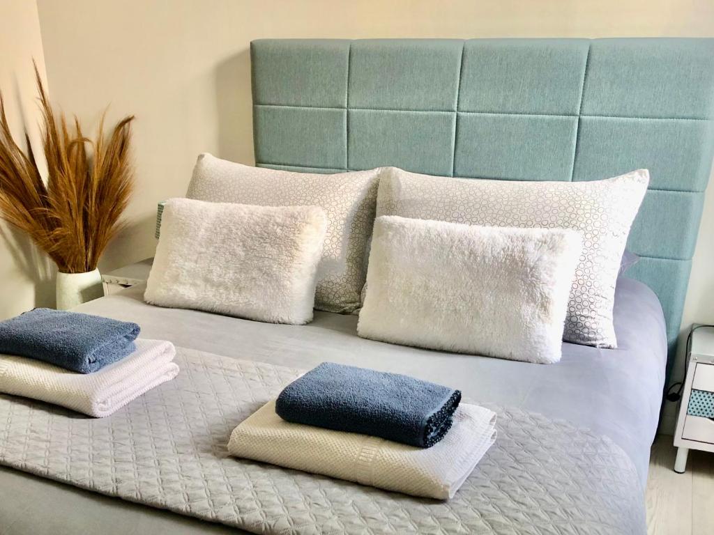 un lit avec quatre oreillers dessus dans l'établissement Maison Cosy La Jolie Fécampoise, à Fécamp