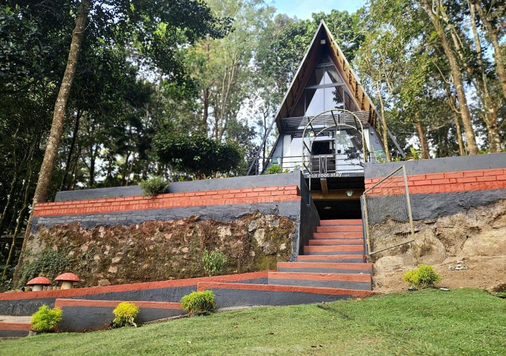 une maison sur une colline avec des escaliers menant à celle-ci dans l'établissement Wild root stay- Orchid Chalet, à Vythiri