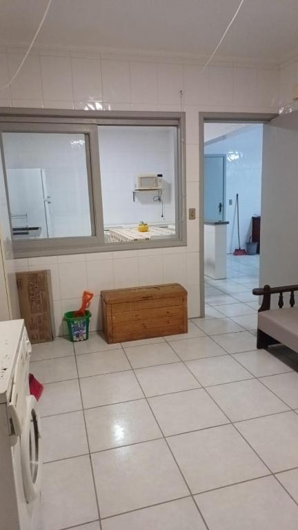 una cucina con pavimenti piastrellati bianchi e una stanza con finestre di Apartamento Centro de Torres a Torres