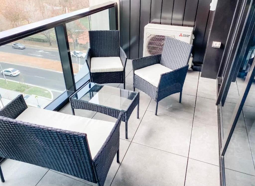 un grupo de sillas y una mesa en el balcón en City-Self check in-Parking-Pool, en Canberra