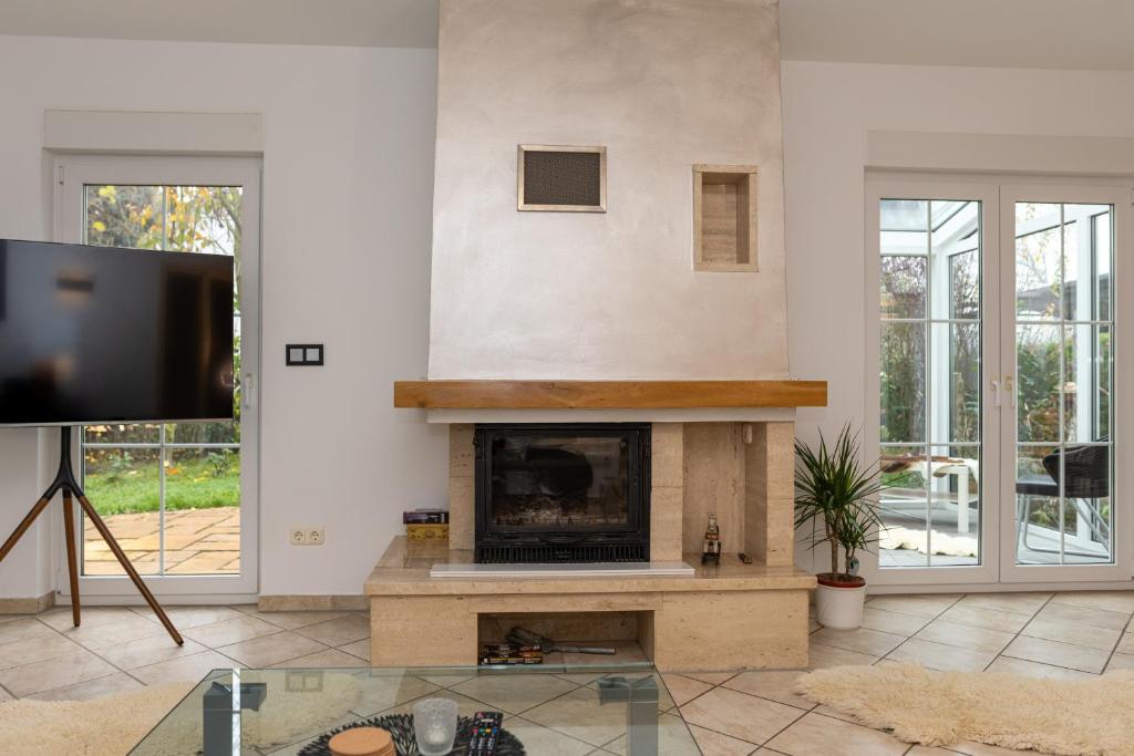 a living room with a fireplace and a tv at Ganzes Ferienhaus in Leipzig mit Garage und Fußbodenheizung in Leipzig