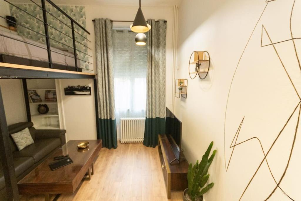 un salon avec un canapé et une table dans l'établissement La Mezzanina - Hypercentre - Gare, à Angers