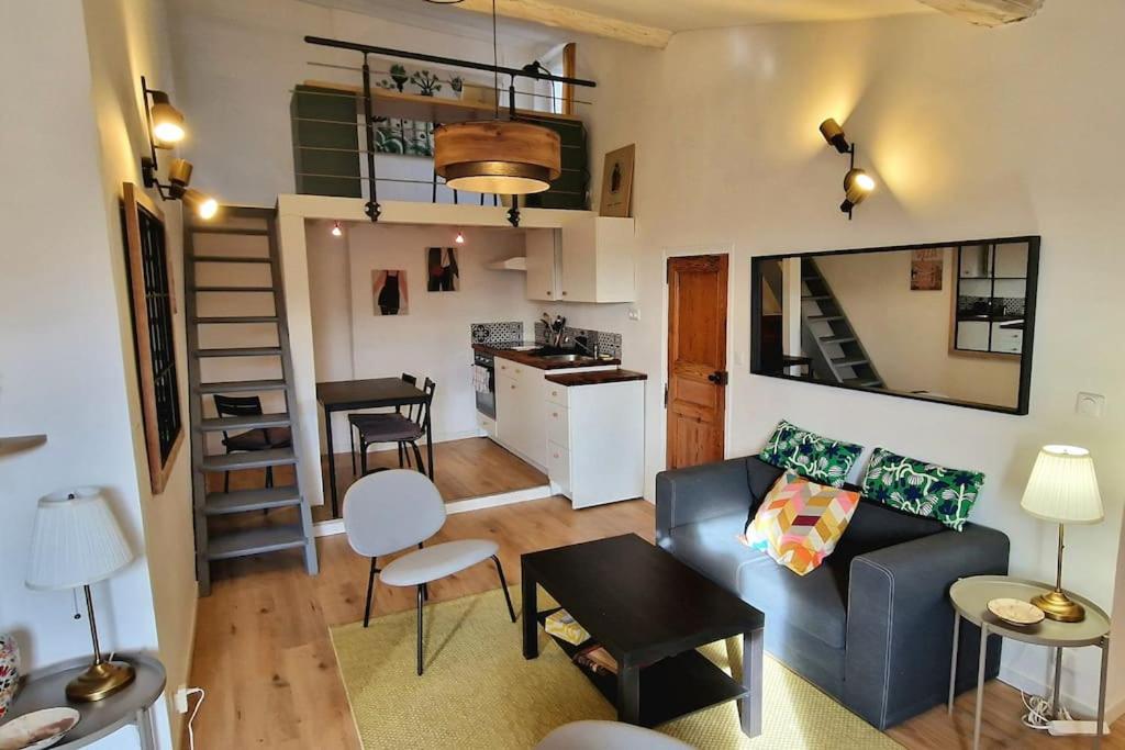 un salon avec un canapé bleu et une cuisine dans l'établissement Cocon ensoleillé centre ville historique, Clim Wifi 4 people, à Aix-en-Provence