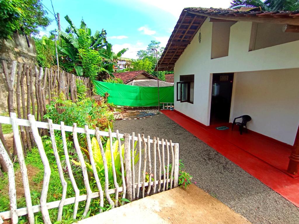 a white fence in front of a house at vihanga homestay in Mirissa