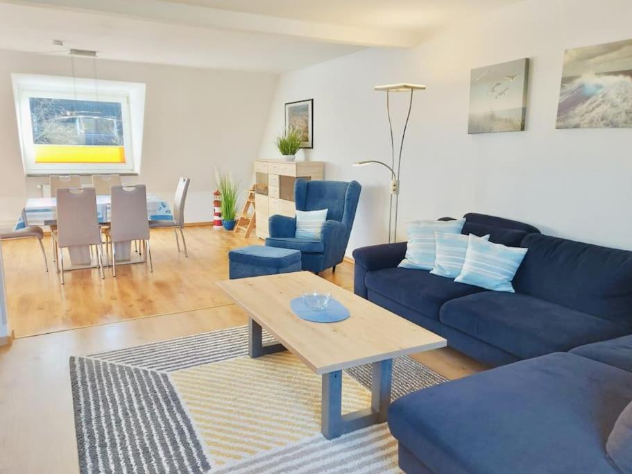 a living room with a blue couch and a table at Wolke 7 von OstseeAhoi in Lübeck