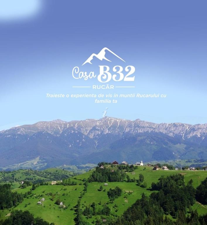 a view of a green field with mountains in the background at Casa B32 Spa Rucar in Rucăr