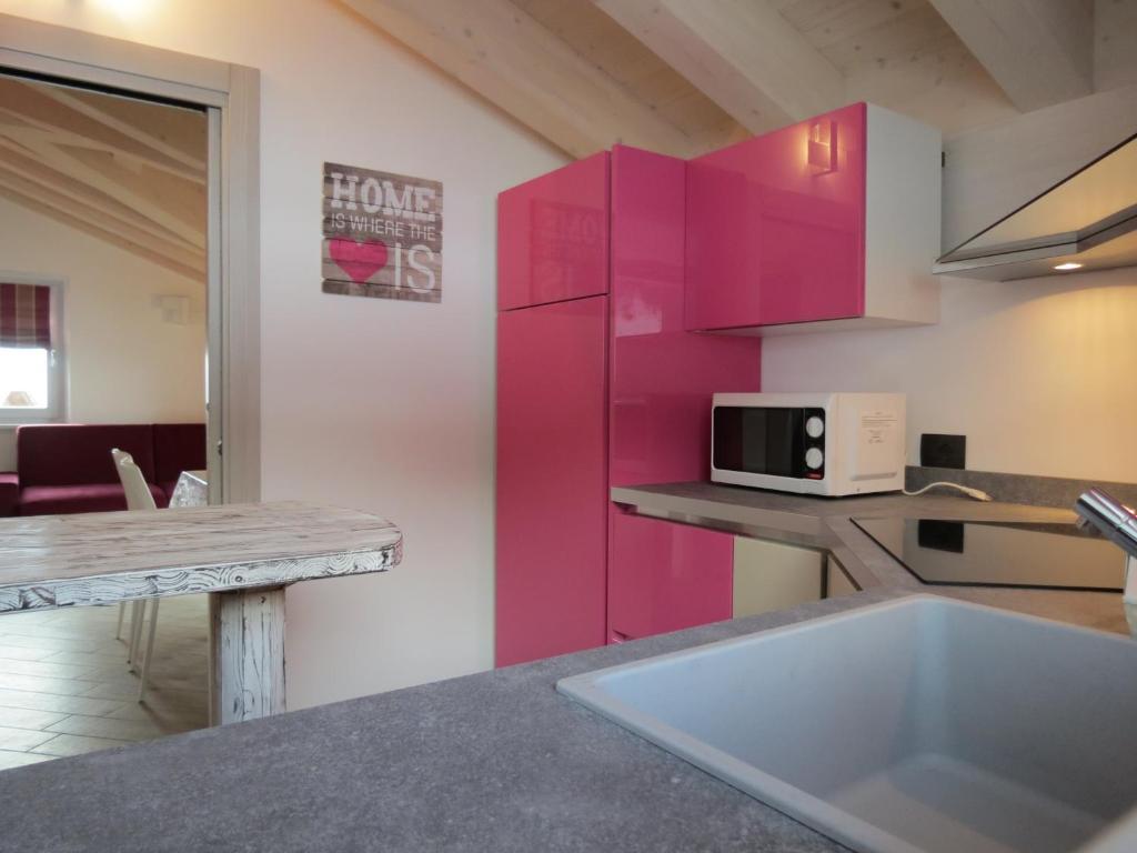 cocina con armarios rosados y fregadero en Al Dos en Livigno